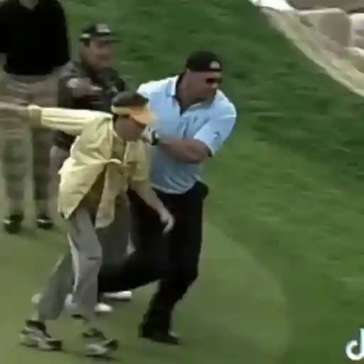 Man gets tackled at a golf tournament.